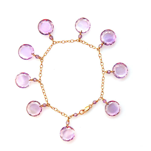 A 14k yellow gold bracelet with round amethyst gemstone discs, on a white background.