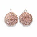 A pair of rose gold-colored earrings with purple amethyst beads, crocheted with 14k rose gold wire.