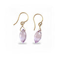 Gold earrings with purple gemstones on a white background