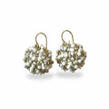 Pair of gold and white beaded earrings on a light background