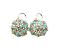 Pair of gold and turquoise beaded earrings on a white background