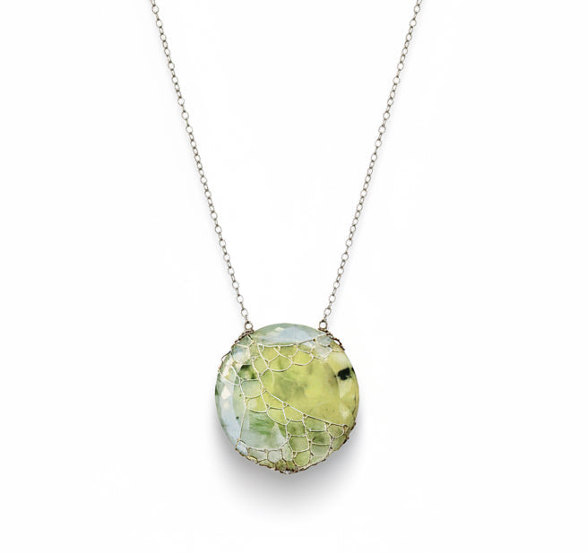 Necklace with a green stone pendant on a white background